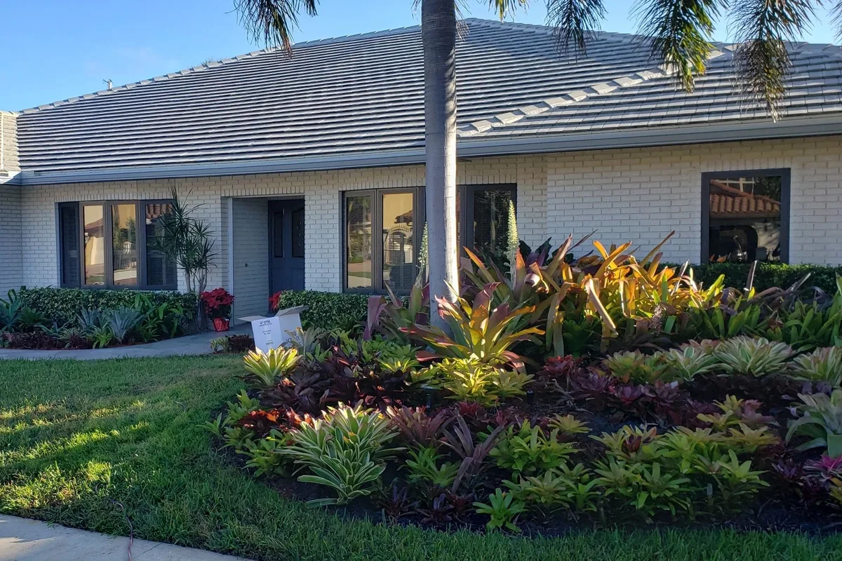 South Florida home with white gutters and tropical landscaping, photo from our original 2020 website